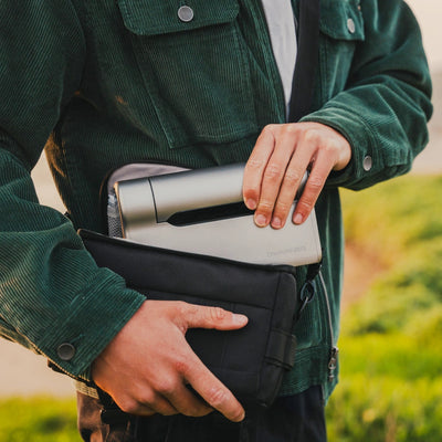 a person holding a bag with a silver device in it